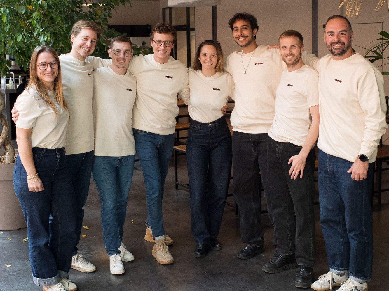 L'équipe AQQI réunie dans ses bureaux, en t-shirts et sweats AQQI.